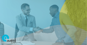 Two men shaking hands and smiling at each other