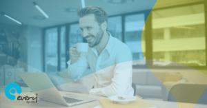 Man sitting at a desk drinking a coffee looking at a laptop. An Every HR By IRIS gradient overlays the image.